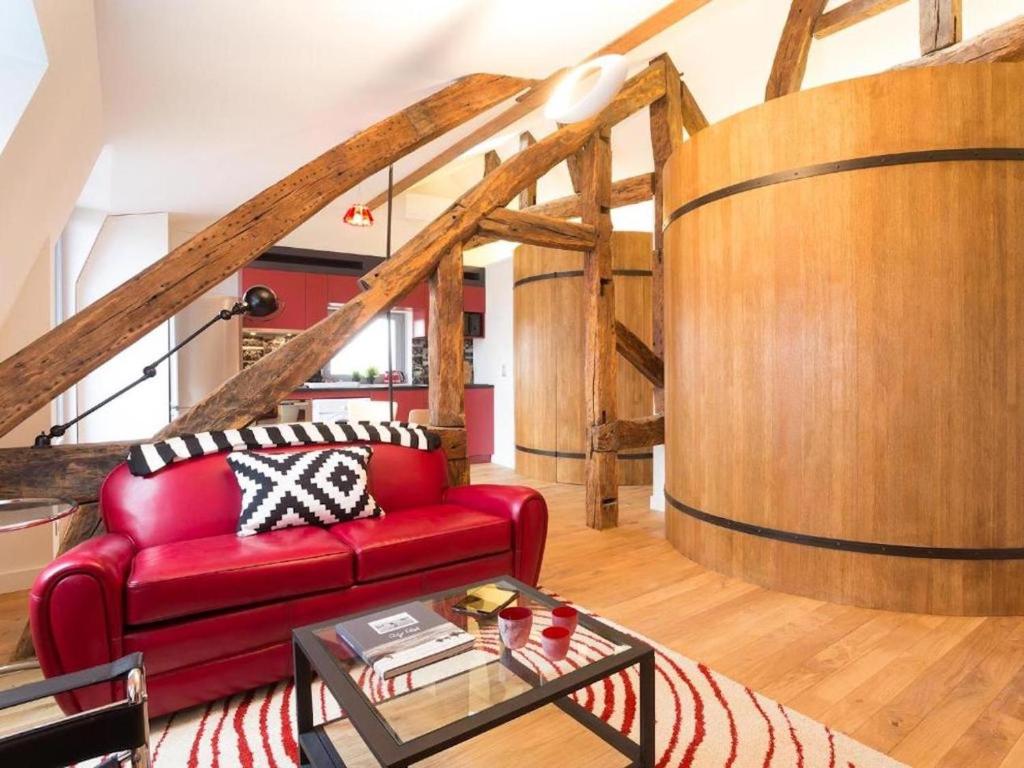 - un salon avec un canapé rouge et un tonneau de vin dans l'établissement Dijon La Belle Adresse, à Dijon