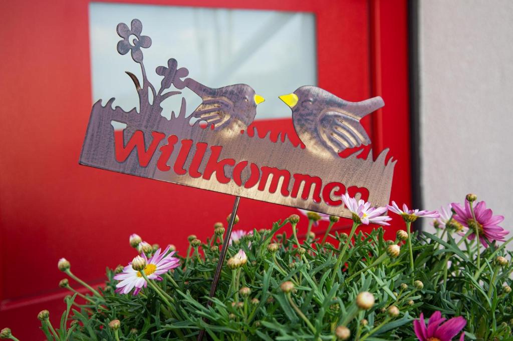 two birds sitting on a sign in front of a door at Meinel's Inn in Dreifelden