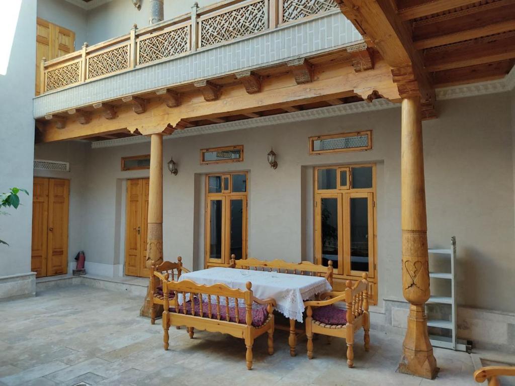 uma sala de jantar com mesa e cadeiras e uma varanda em Hotel Nazira & Azizbek 2 em Bukhara