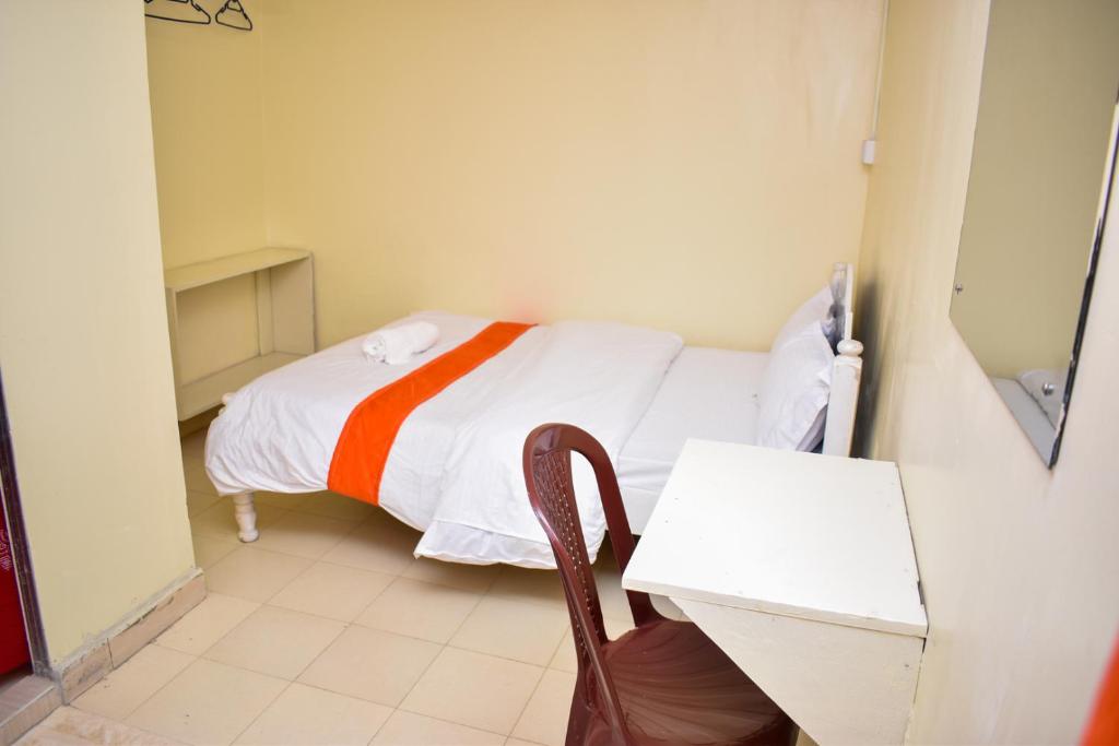 a small room with a bed and a table at Luna Light Guest House in Naivasha