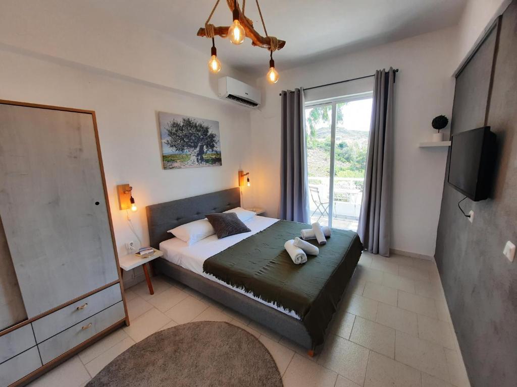 a bedroom with a large bed and a television at Elia Boutique Studios in Kalithies