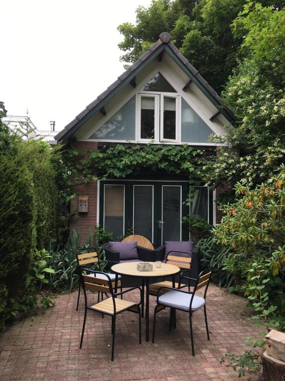 a wooden table and chairs in front of a house at Villa Hoog Duin in Domburg