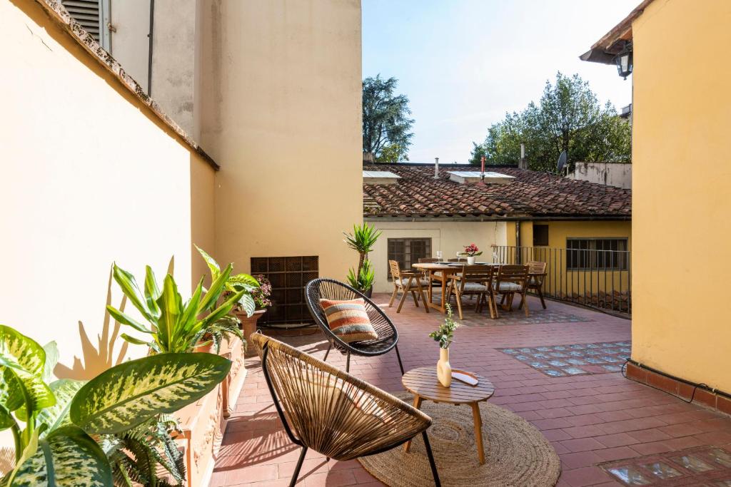 eine Außenterrasse mit Stühlen, Tischen und einem Tisch in der Unterkunft Apartments Florence - Alfani Terrace in Florenz