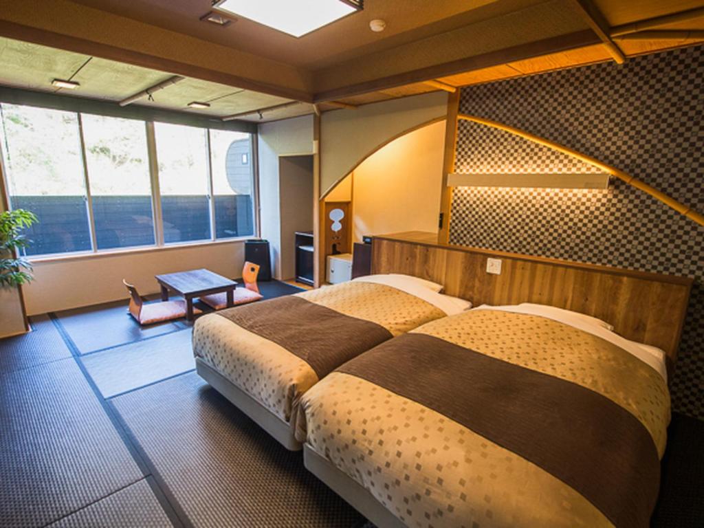 Llit o llits en una habitació de LiVEMAX RESORT Shizuoka Amagiyugashima