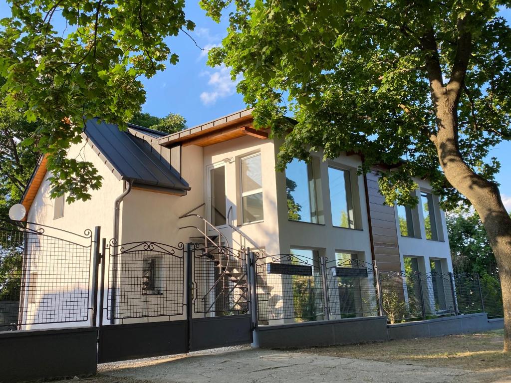 dom z bramą i drzewem w obiekcie BIKE & FUN Apartments - Balatonakarattya w mieście Balatonakarattya