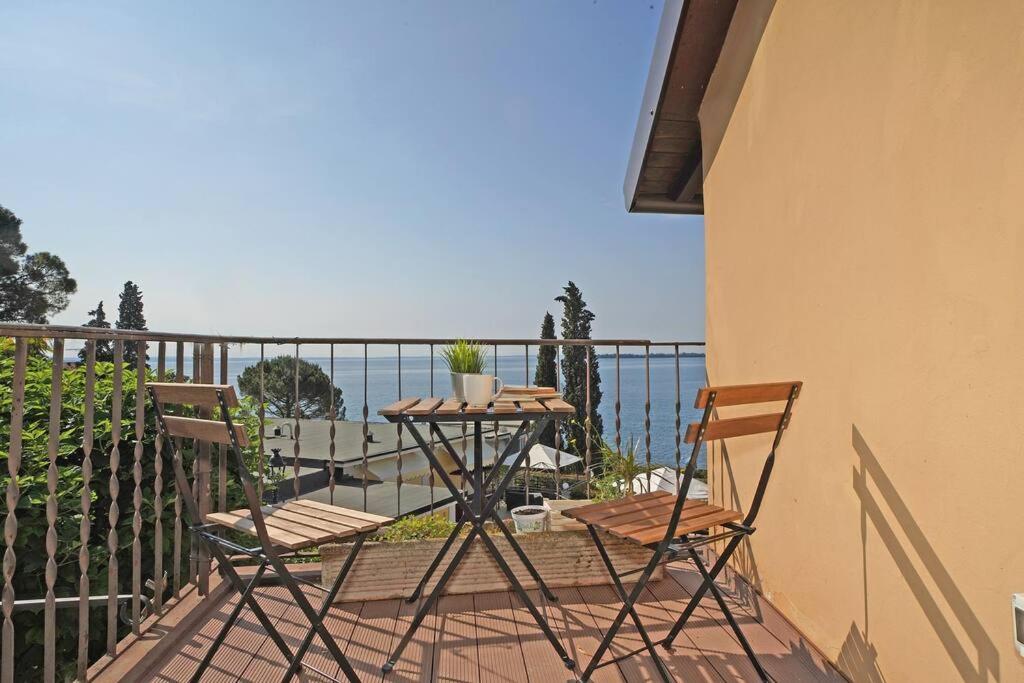 d'une table et de chaises sur un balcon donnant sur l'océan. dans l'établissement Fasano home with terrace and Lake view, à Gardone Riviera