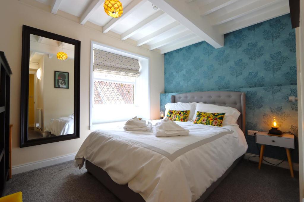 um quarto com uma cama com um espelho e uma janela em The Little Lion Inn, Red Lion em Wellingore
