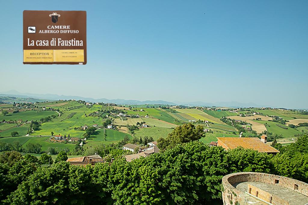 een bord voor een boerderij met uitzicht op een vallei bij casa di Faustina (albergo diffuso) in Corinaldo
