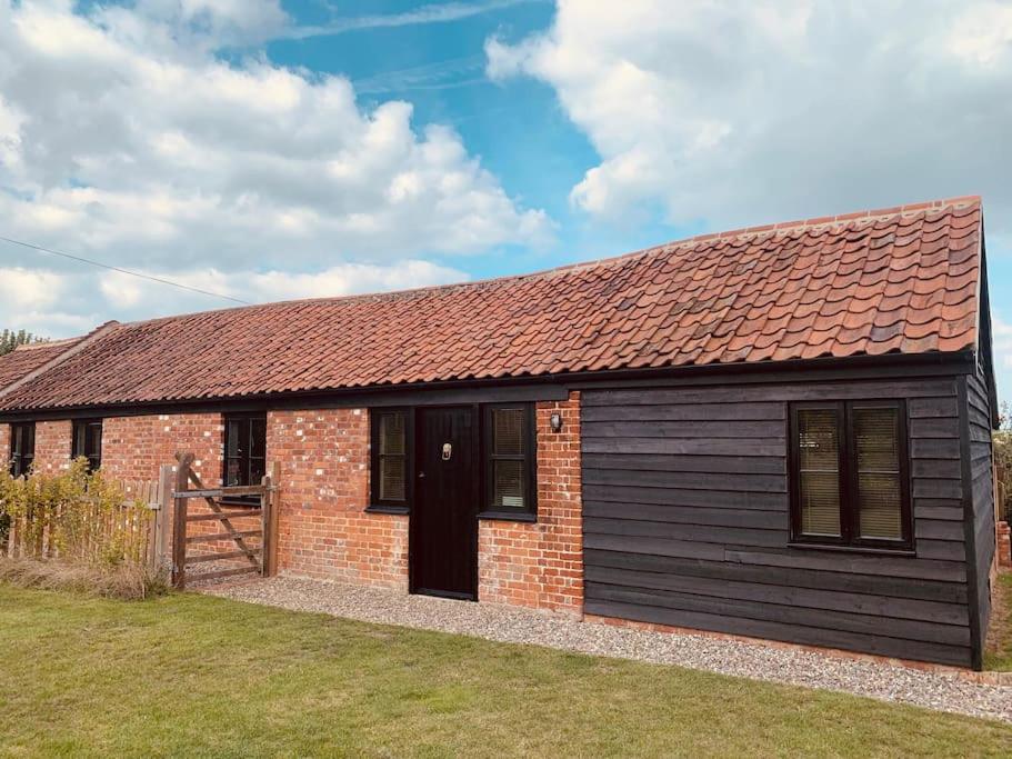 una pequeña casa de ladrillo con techo rojo en Bonneys Barn Retreat - Luxury homely getaway, en Burgh Saint Peter