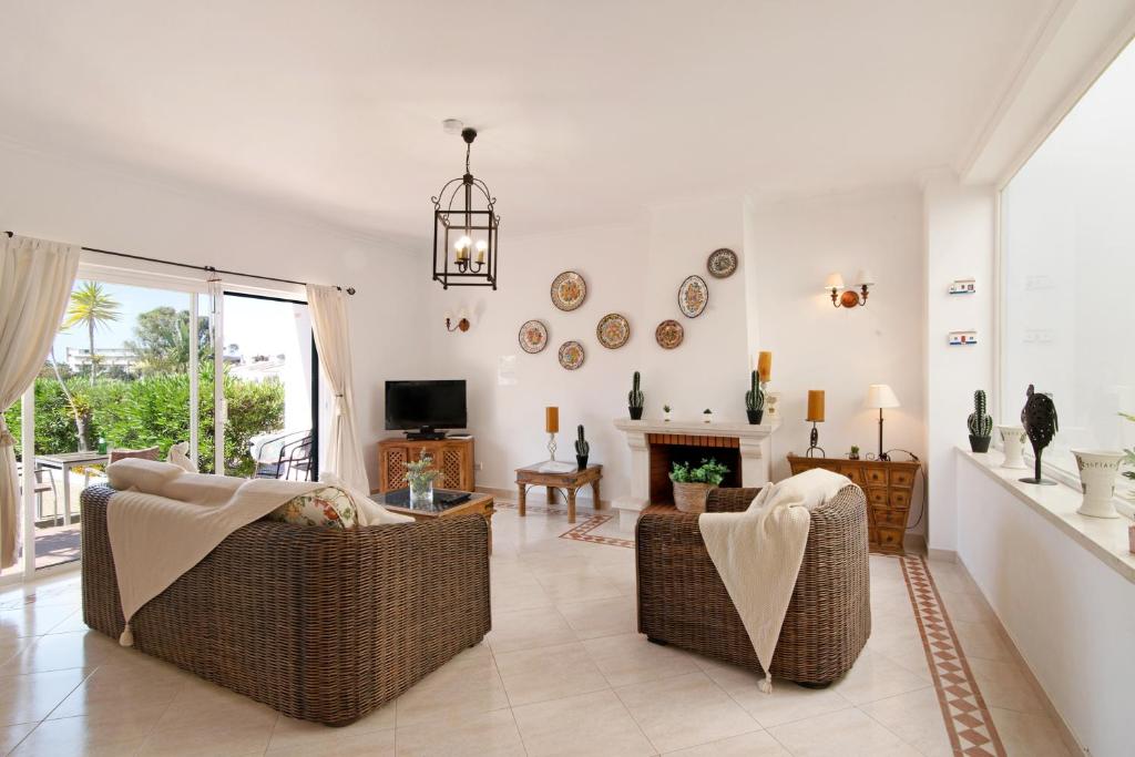 uma sala de estar com duas cadeiras e uma lareira em Casa Marisol Albufeira em Albufeira