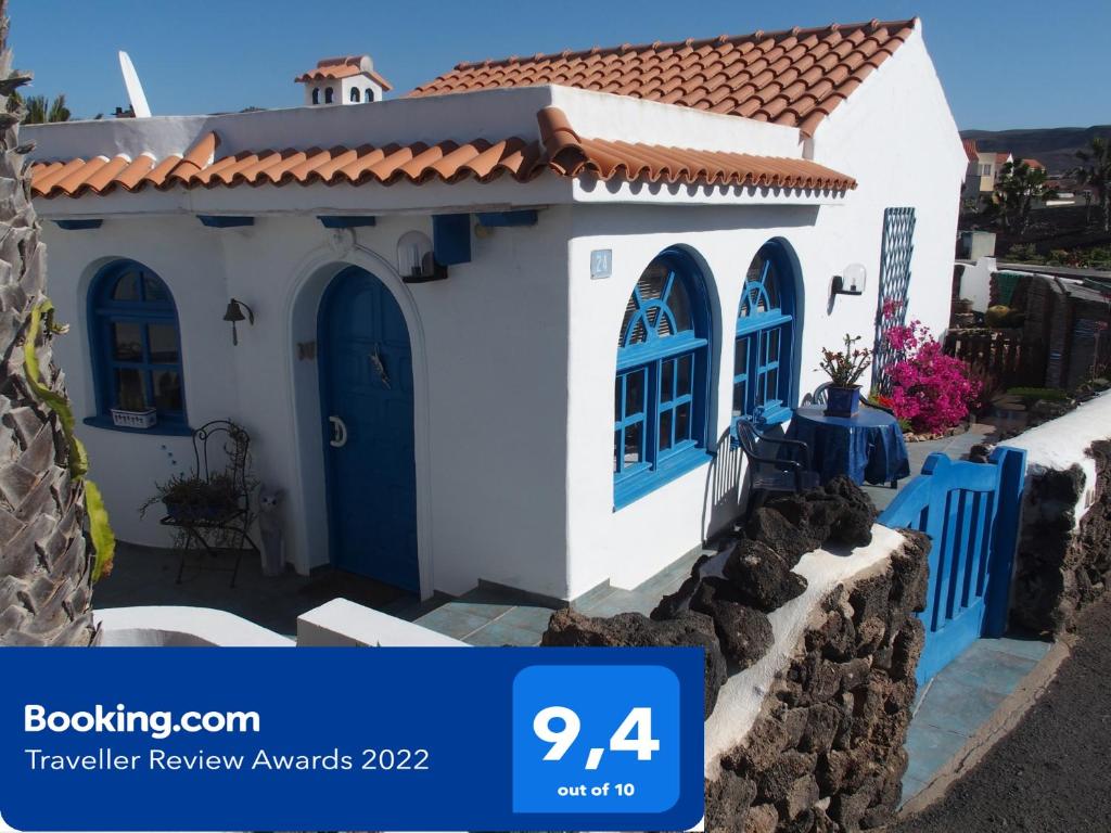 a small white house with blue doors and a tile roof at CASA CALMA in La Pared