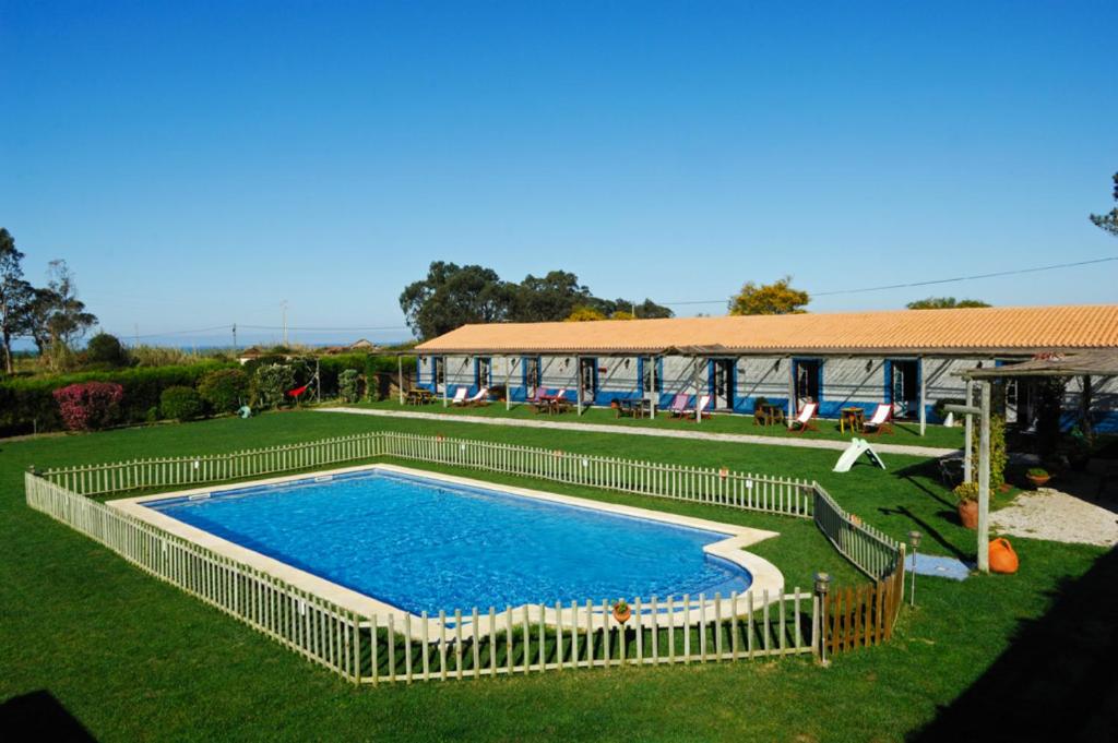 a large swimming pool in a yard next to a building at Casa Da Seiceira in São Teotónio