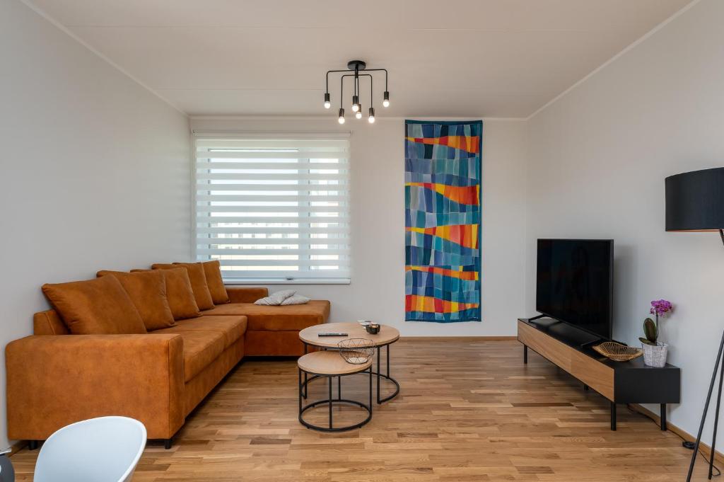 uma sala de estar com um sofá e uma mesa em CITYGATE APARTMENT WITH SUN BALCONY em Tartu