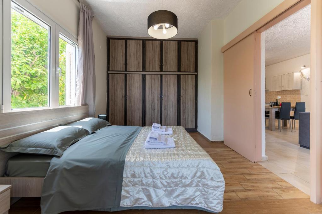 ein Schlafzimmer mit einem Bett und einem großen Fenster in der Unterkunft Doukas House Cottage with vineyard, Artemis in Artemida
