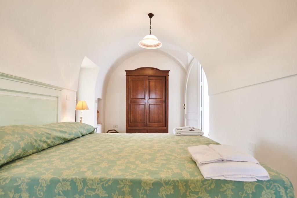 sypialnia z dużym łóżkiem z drewnianymi drzwiami w obiekcie Villa Pompea al piano terra - Apulia Home w mieście Casarano