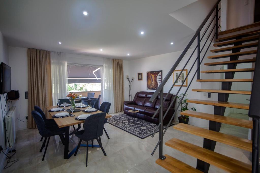 a living room with a dining table and a staircase at Iadertina Apartment in Zadar