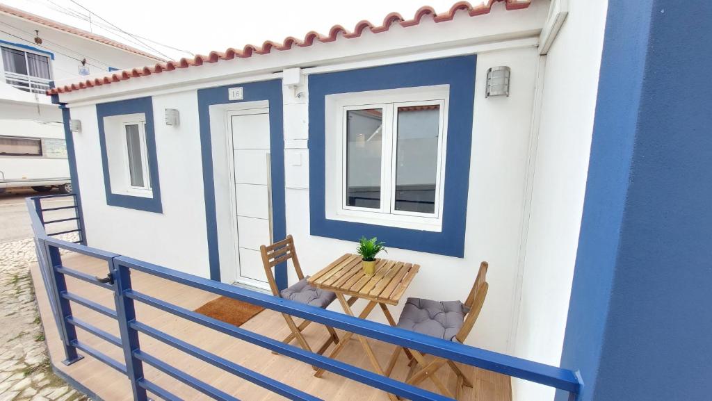 een blauw-wit huis met een tafel en stoelen bij Airport house in Faro