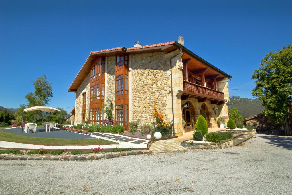 une grande maison en pierre avec une grande allée. dans l'établissement Villa Arce Hotel, à Puente Viesgo