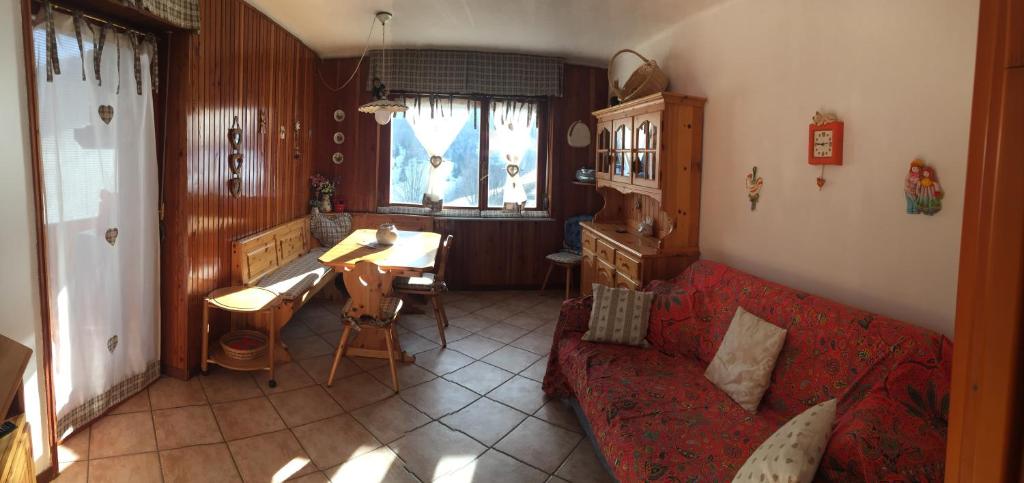 a living room with a red couch and a table at SCI AI PIEDI in Limone Piemonte