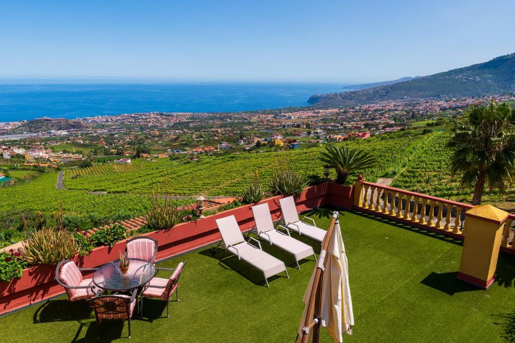 a balcony with chairs and a view of a vineyard at CASA RURAL EL ESQUILON TENERIFE in La Orotava