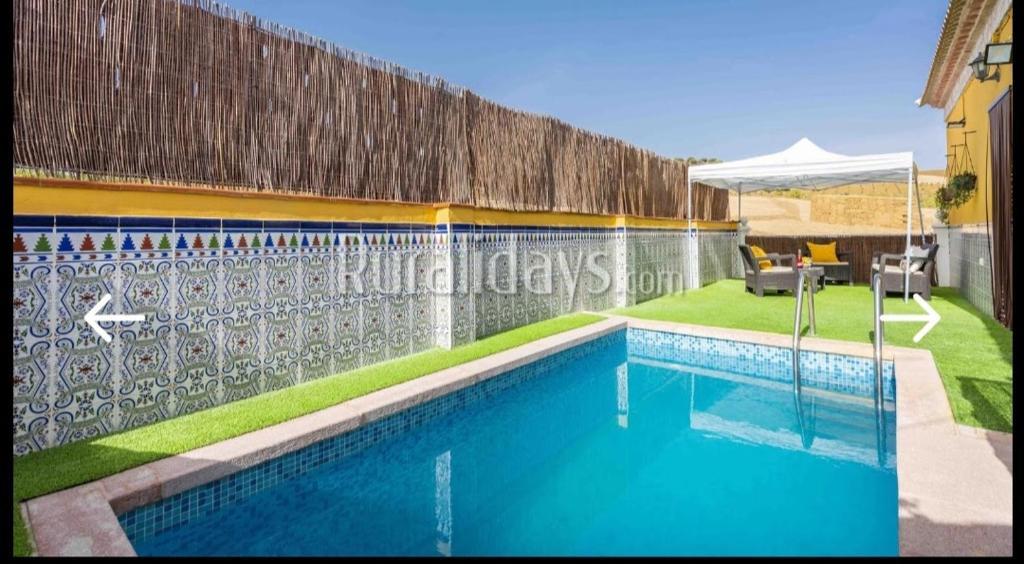 a swimming pool in a yard with a fence at Casa rural Los Alcaidejos con piscina in Málaga