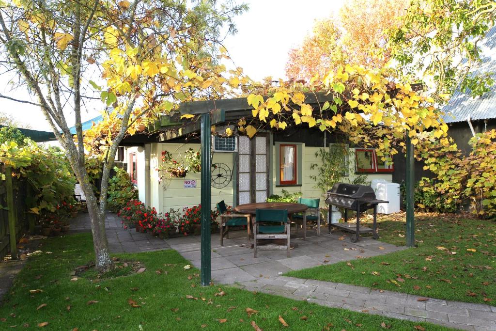 a patio with a table and a grill in a yard at The Berry Farm Retreat in Hastings