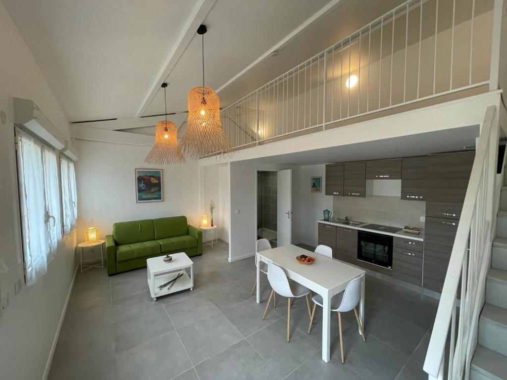 uma sala de estar com uma mesa e um sofá verde em Les Salines Oléron em Saint-Pierre-dʼOléron