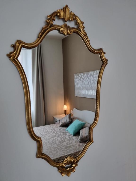 uno specchio appeso a una parete con un letto di Nel cuore del Centro Storico a Torino