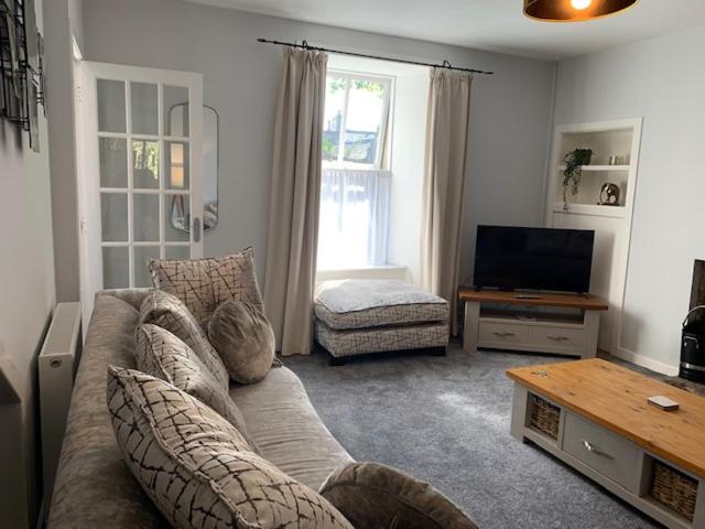 uma sala de estar com um sofá e uma televisão em Victoria Cottage, 8 Victoria Road em Orkney