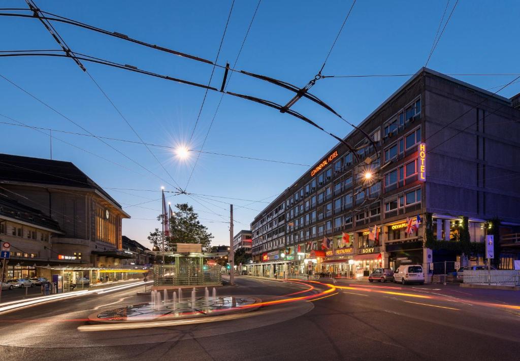 een stadsstraat 's nachts met verkeer bij Continental Hotel Lausanne in Lausanne