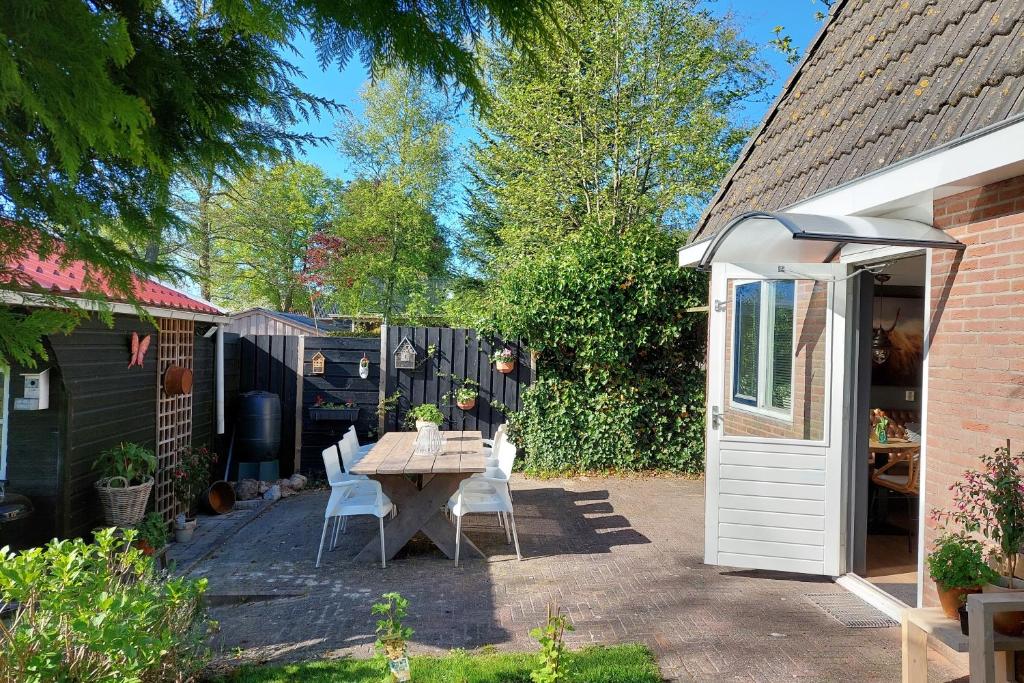 een patio met een tafel en stoelen in de achtertuin bij Tusken Wad en Wâld in Kollumerzwaag