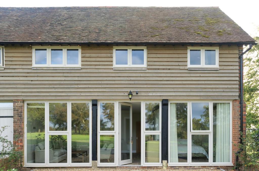 una casa con grandes puertas correderas de cristal en Greentrees Estate - Pine Cottage, en Balcombe