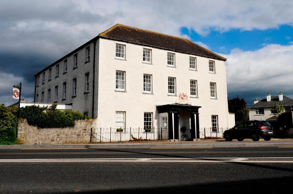 um edifício branco ao lado de uma rua em Ashbrook Arms Townhouse and Restaurant em Durrow