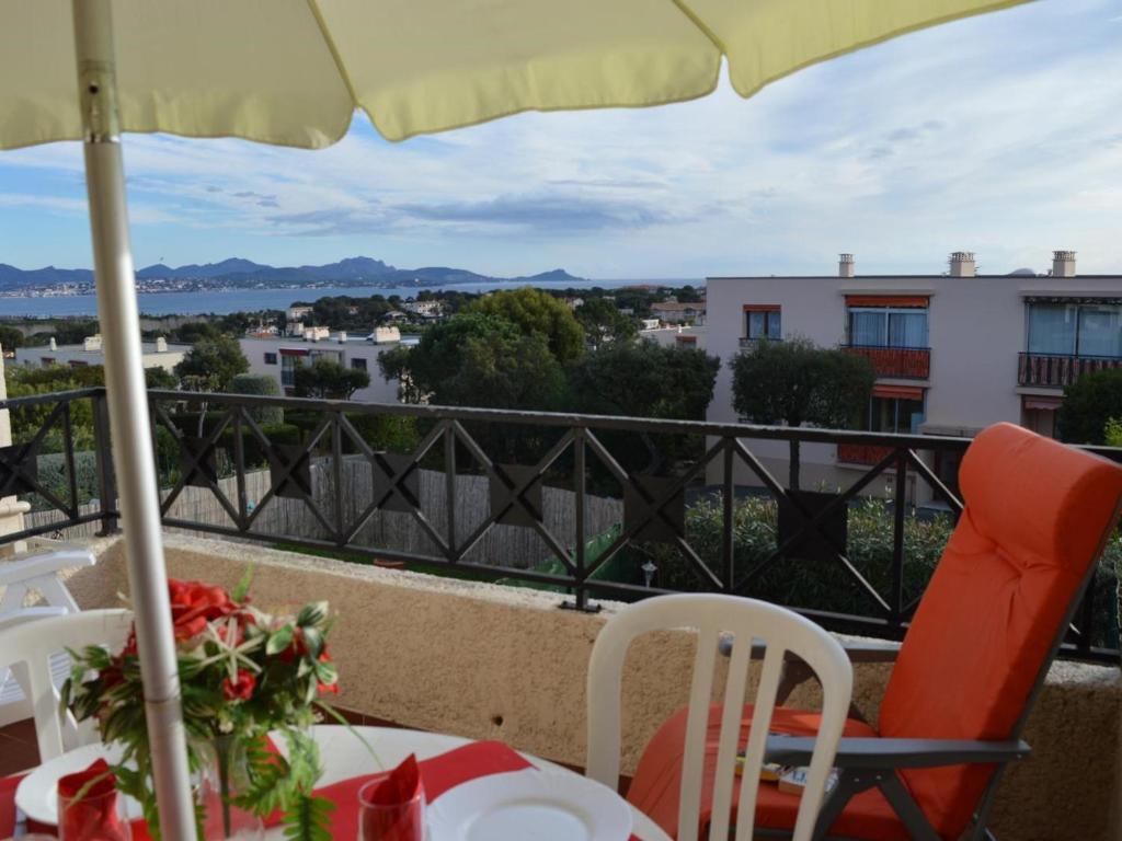 een balkon met een tafel en stoelen en een parasol bij Appartement Saint-Aygulf, 2 pièces, 4 personnes - FR-1-226A-14 in Saint-Aygulf