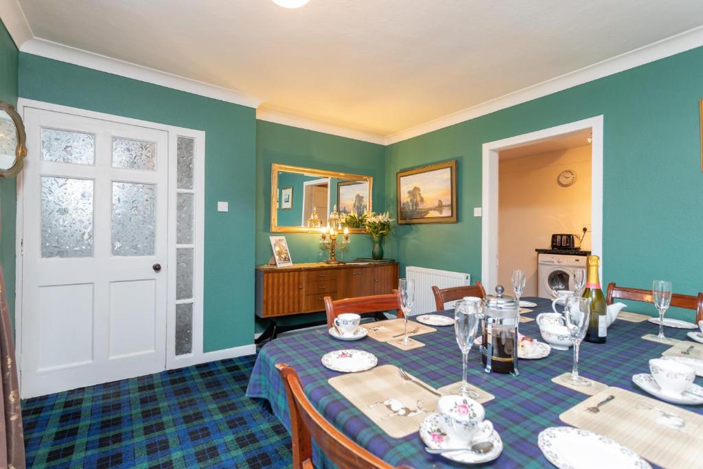 a dining room with green walls and a table at The Auld Sweetie Shop in Perth