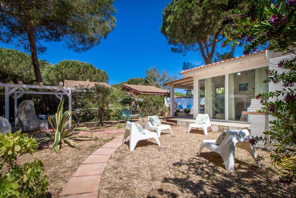 einen Hof mit weißen Stühlen und ein Haus in der Unterkunft Carlotta in Codaruina