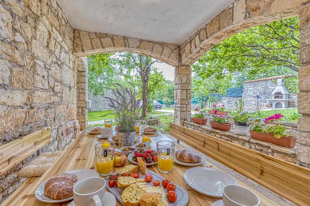 stół z jedzeniem na kamiennej ścianie w obiekcie Eden house w mieście Kanfanar