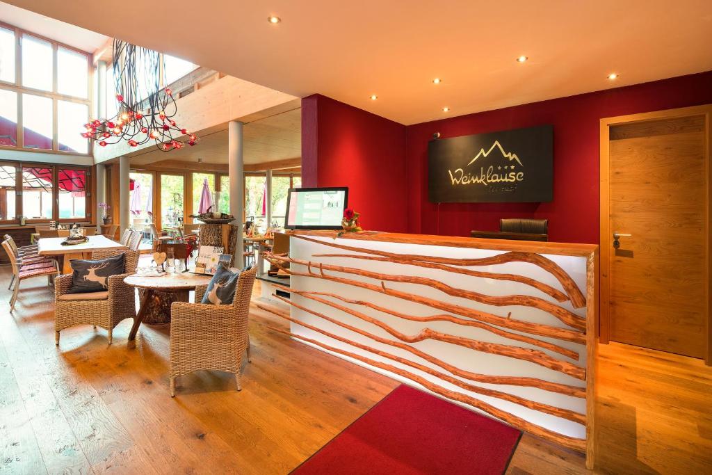 ein Restaurant mit roten Wänden, Tischen und Stühlen in der Unterkunft Aparthotel Weinklause Superior in Oberstdorf