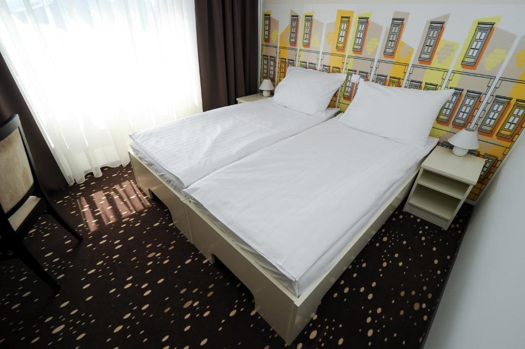 Postel nebo postele na pokoji v ubytování City Hotel Krško