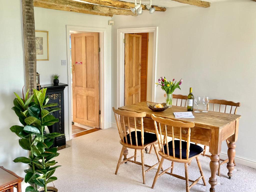 comedor con mesa de madera y sillas en The Cottage en York