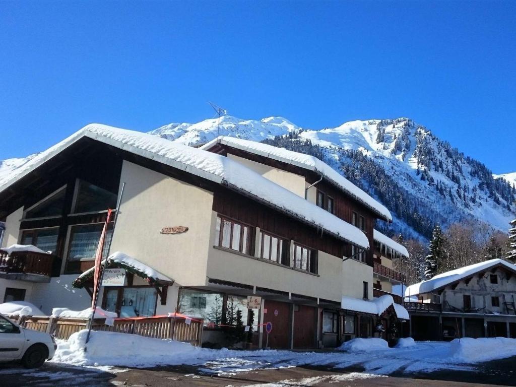 un edificio con nieve en él con montañas en el fondo en Appartement chaleureux 6 pers. au pied des pistes et des randonnées, classé 2 étoiles - FR-1-342-195, en Arêches