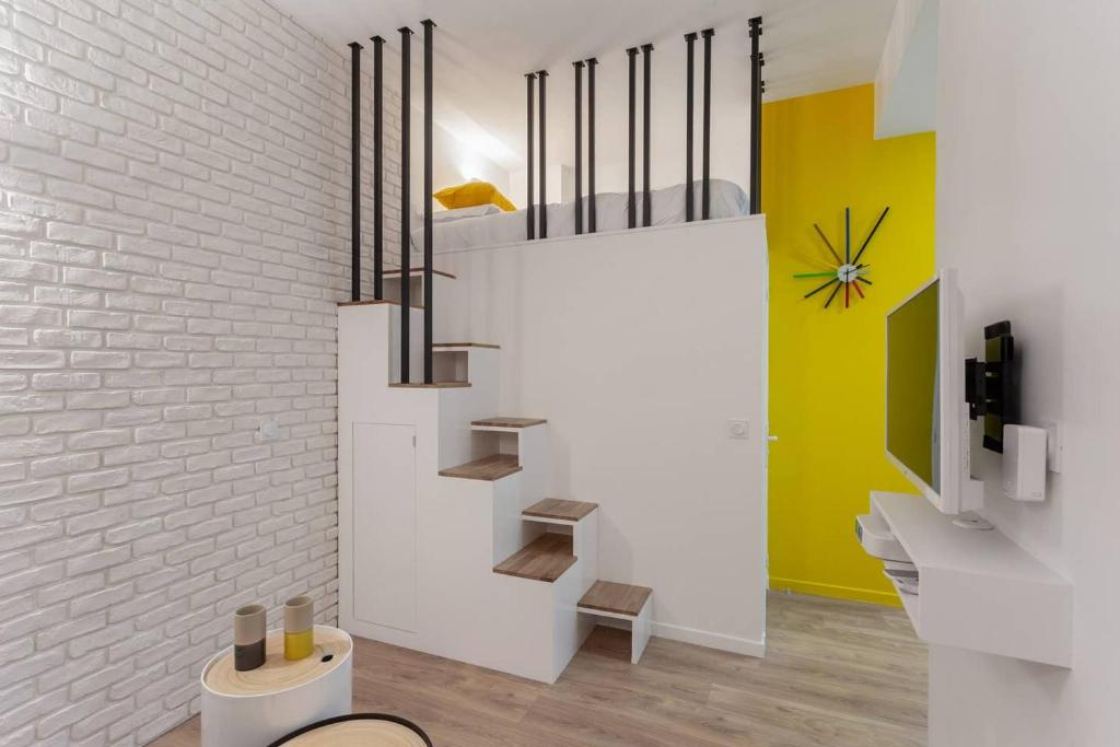 - un escalier dans une chambre dotée d'un mur en briques blanches dans l'établissement Chic Saint-Germain-des-Prés Studio for 4 - Prime location, à Paris