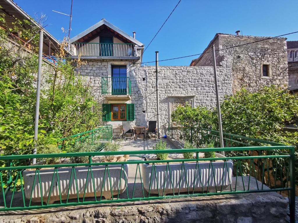 a house with a dog sitting on a balcony at Authentico Deluxe Stari Grad in Stari Grad