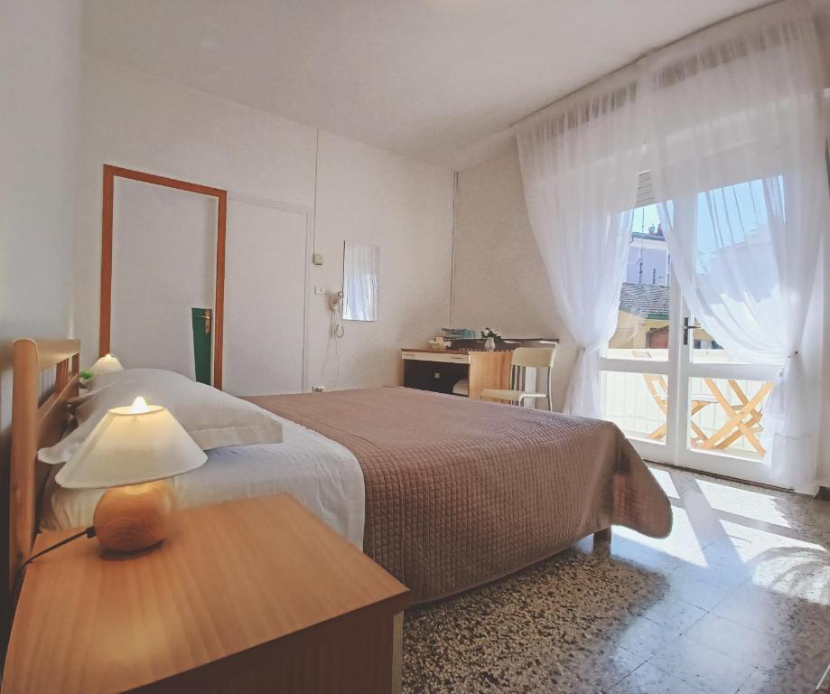 um quarto com uma cama e uma grande janela em BeeLiving Room&Breakfast em Riccione
