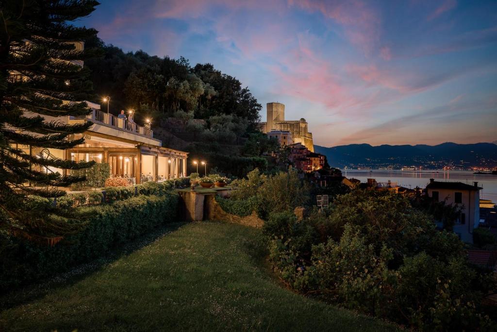 a house on the shore of a lake at night at Doria Park Hotel in Lerici