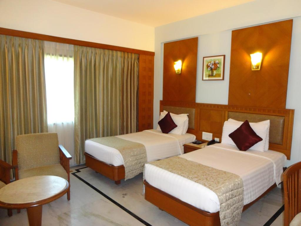 Postel nebo postele na pokoji v ubytování JP Chennai Hotel
