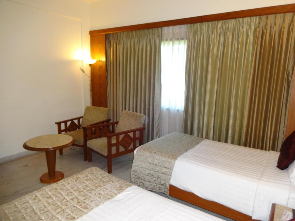 Postel nebo postele na pokoji v ubytování JP Chennai Hotel