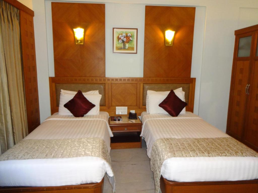 Postel nebo postele na pokoji v ubytování JP Chennai Hotel
