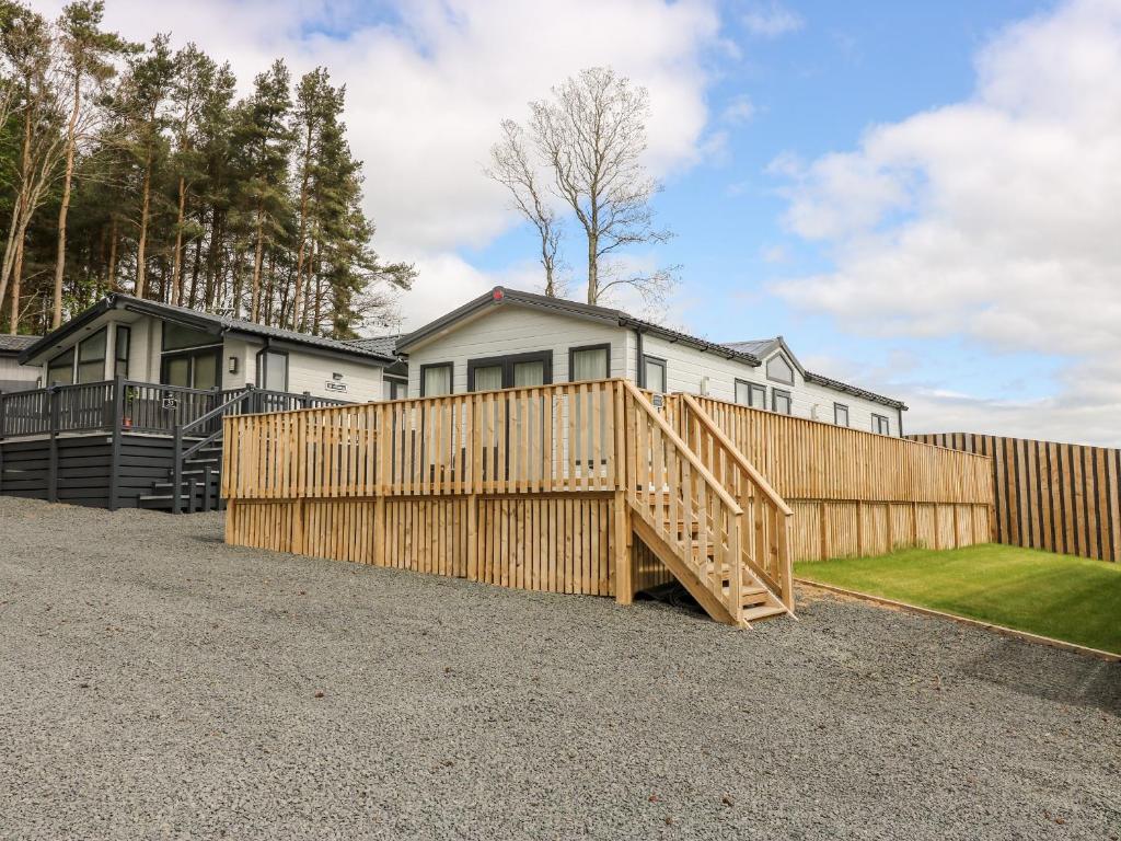 a wooden fence in front of a house at Serena Lodge in Jedburgh