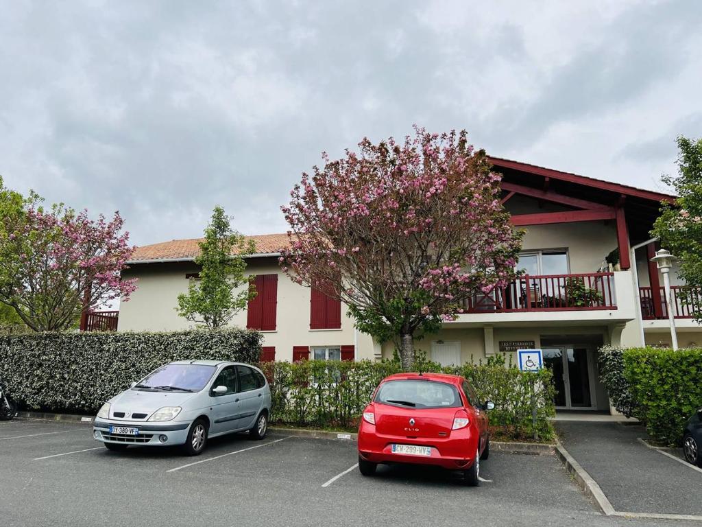 two cars parked in a parking lot in front of a building at Appartement Cambo-les-Bains, 2 pièces, 2 personnes - FR-1-495-8 in Cambo-les-Bains